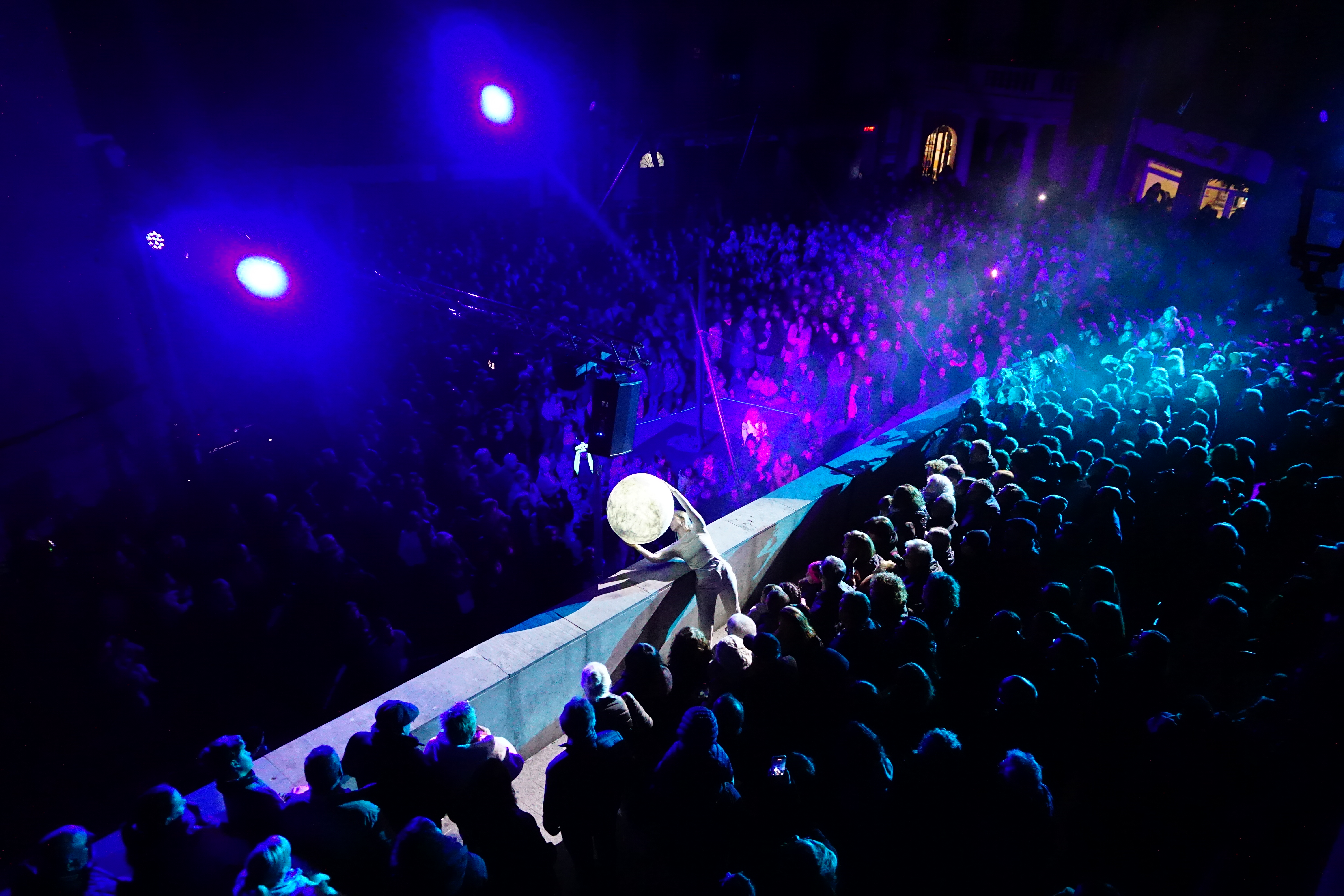 La ballarina i acròbata, Laura Marsal, descendint per la barana de la plaça de Sant Pere, portant la lluna de l'espectacle 'Des del cor'